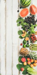 Summer fruits of watermelon halves, cherries, figs, strawberry on wood, with copy space