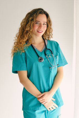 Smiling female doctor standing with crossed arms in room