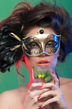 Woman in mask holding glass of drink