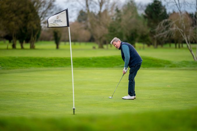 Mature male putting on golf course