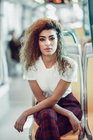 Portrait of serious Arab woman sitting in train carriage looking at camera