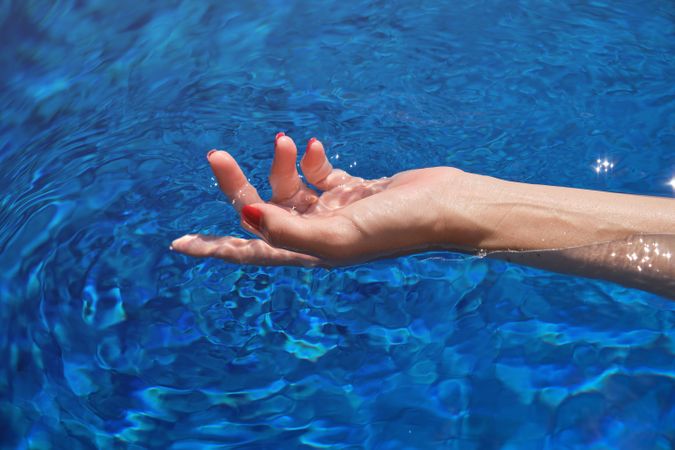 Crop woman in rippling pool water