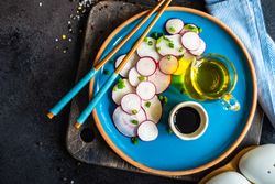 Top view of freshly sliced radishes on blue plate