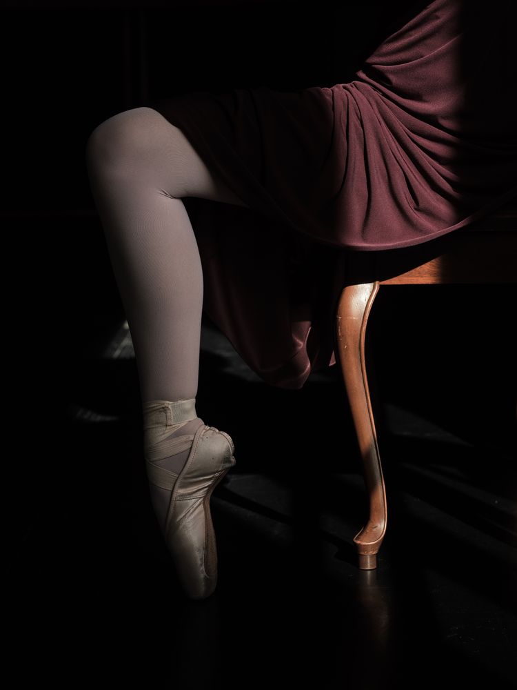 Leg of ballerina standing on tiptoe in pointe shoes