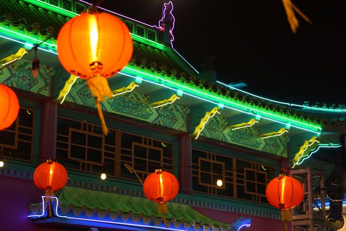 Red lit lanterns near pagoda at night
