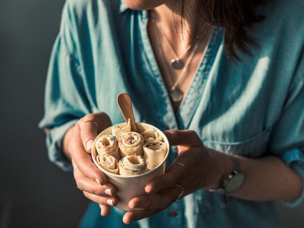 Hand holding rolled ice cream in cone cup