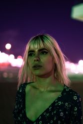 woman looking at camera against vibrant sky at dusk