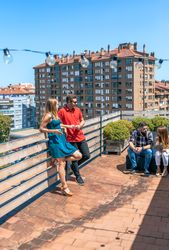 Couple talking next to friends in rooftop on a summer day