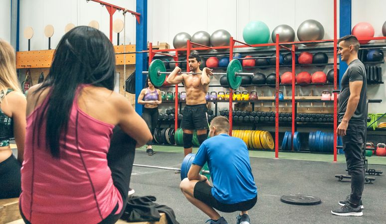 Coach explaining weightlifting in the gym