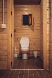 Bathroom in wooden house with opened door