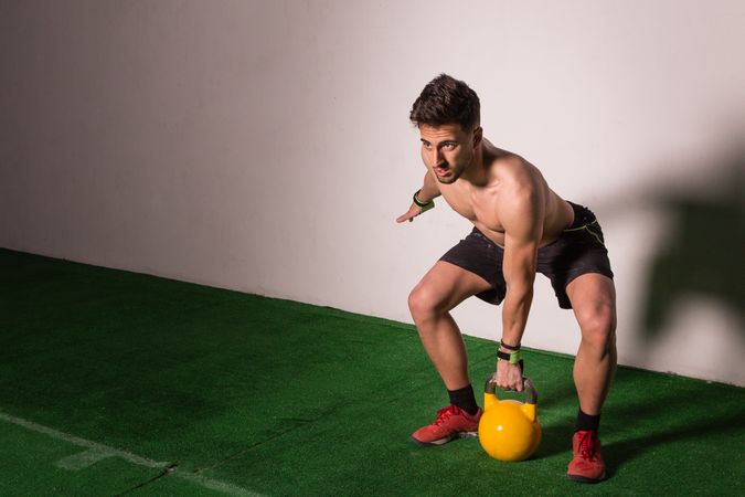 Man lifting kettlebell in gym