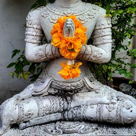 Thai Buddha holding yellow flowers