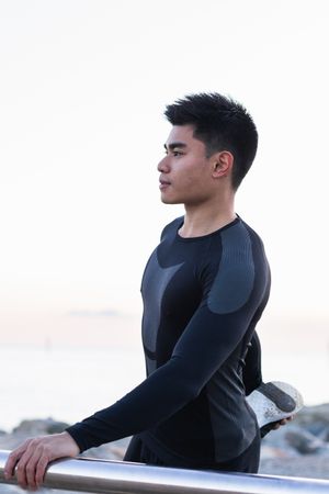 Asian man stretching legs during outdoor workout