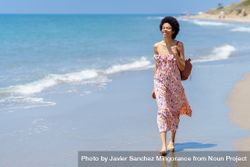 Confident smiling female in maxi dress walking along the coast 5o8Jk4