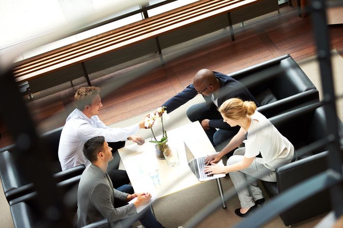 Four business colleagues having an informal meeting in the lobby