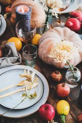 Fall table setting with squash, candles and pomegranates, close up