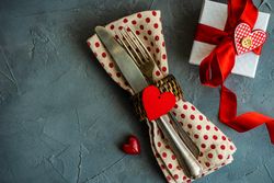 St. Valentine day table setting with dotted napkin wrapped silverware