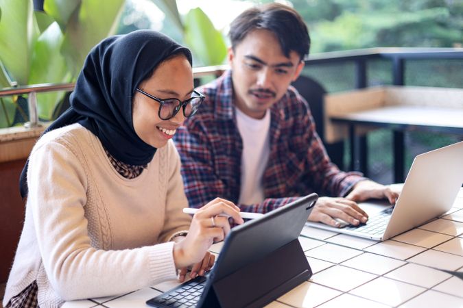 Asian Hijab Female Working at the Cafe with Her Colleague