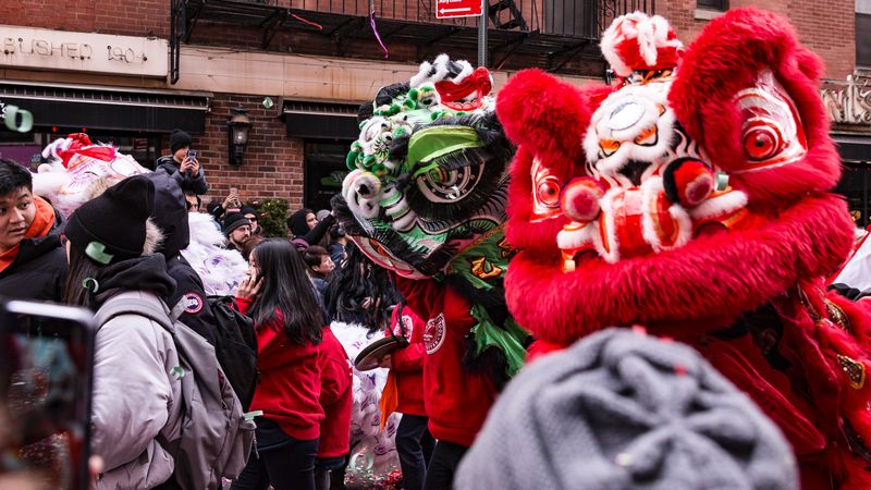Dragon outfit and crowd of people walking in parade as part of Lunar New year tradition