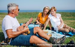 Family on outdoor picnic with ukulele 0vJ9g0