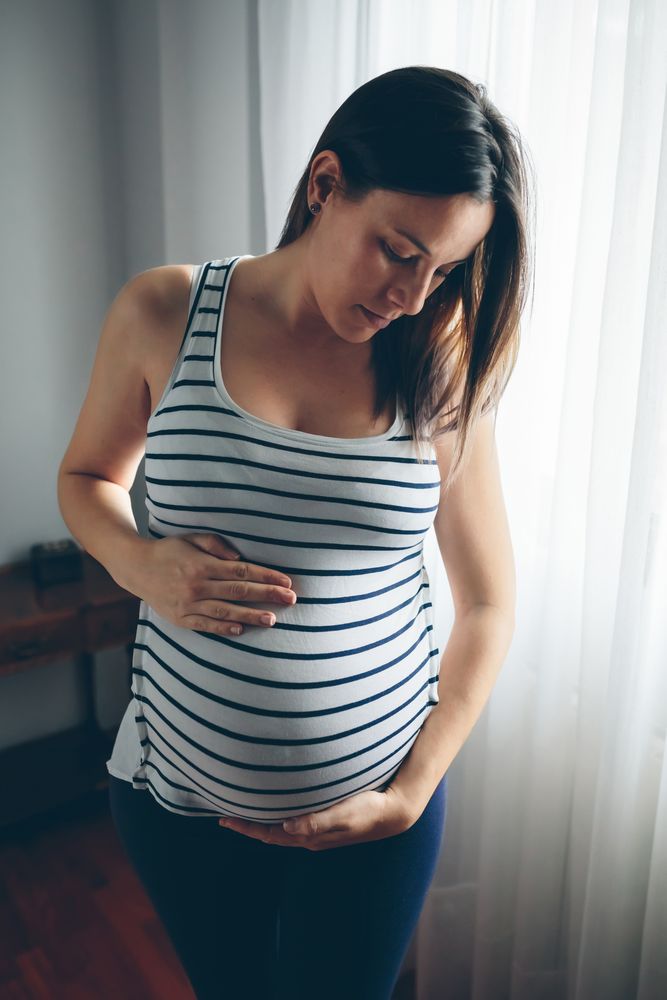 Pregnant woman looking her belly