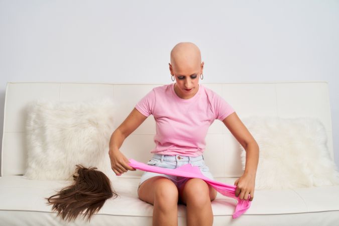 a woman with cancer has taken off her wig and is wearing a pink scarf