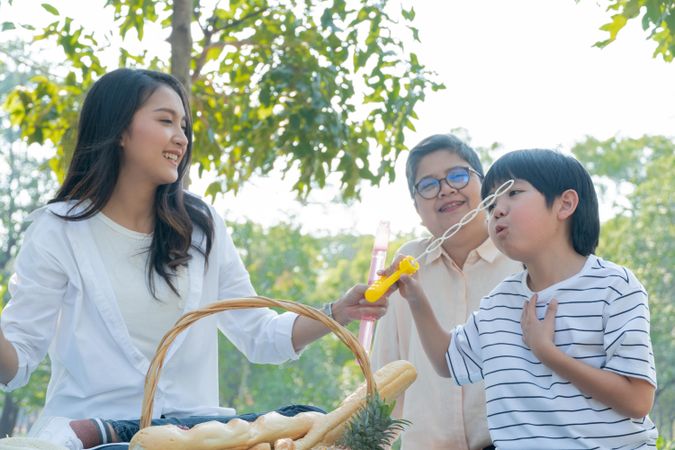 Asian family with picnic basket in a public park