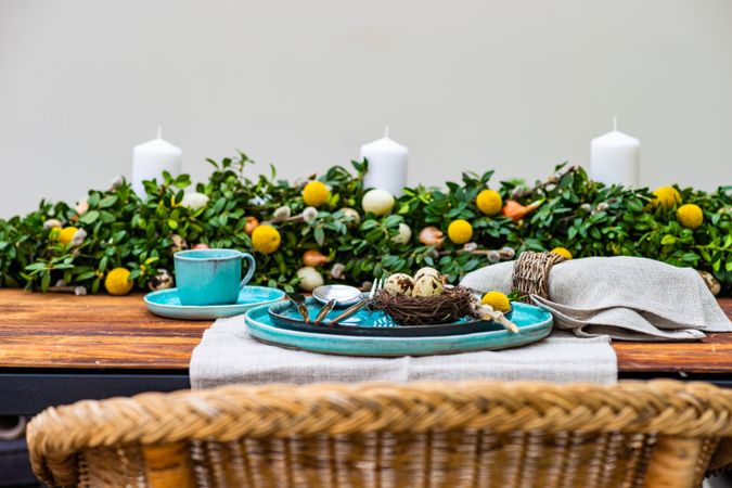 Easter table setting with bird's nest on teal plate
