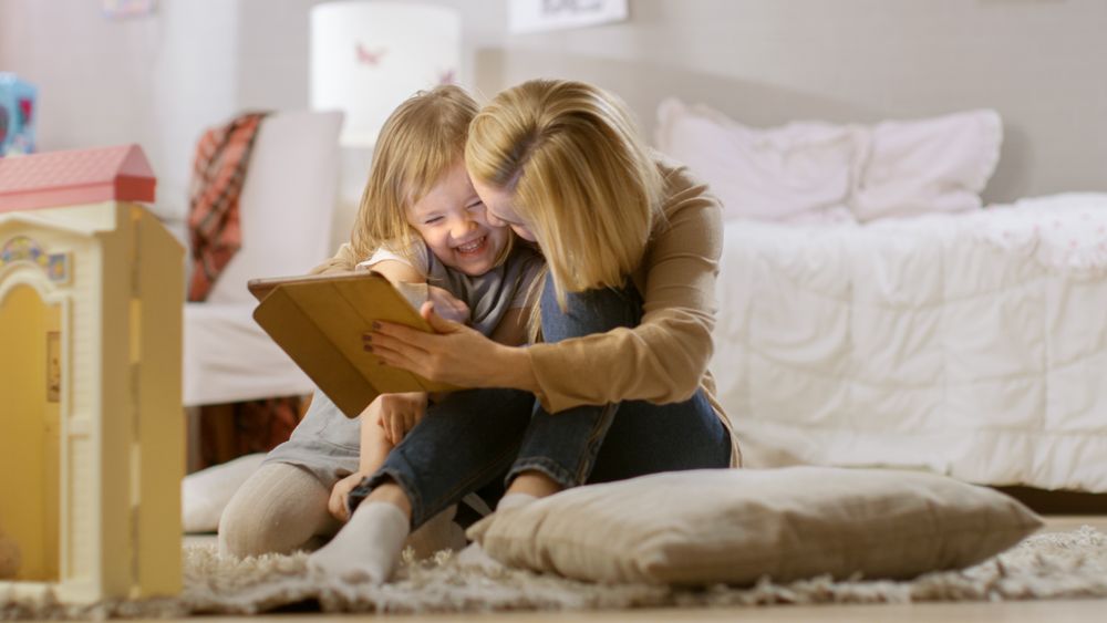 Mother and Her Daughter Have Good Time Reading Children's Books on a Tablet Computer.