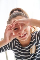 Funny girl making heart gesture