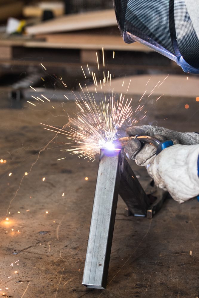 Crop master welding metal pieces at workbench