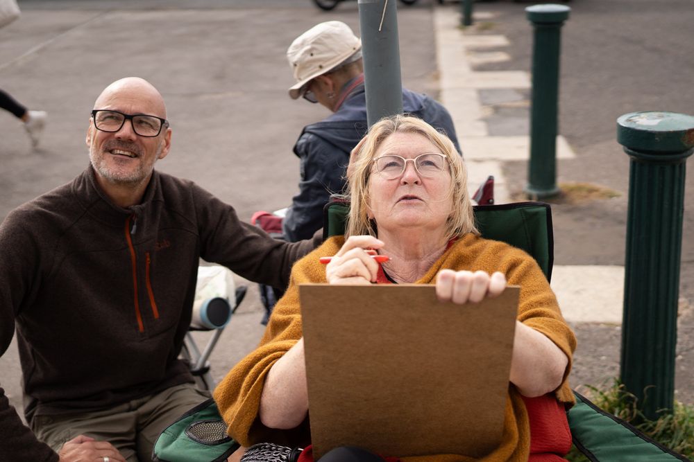 Woman and instructor looking up at their subject during drawing class