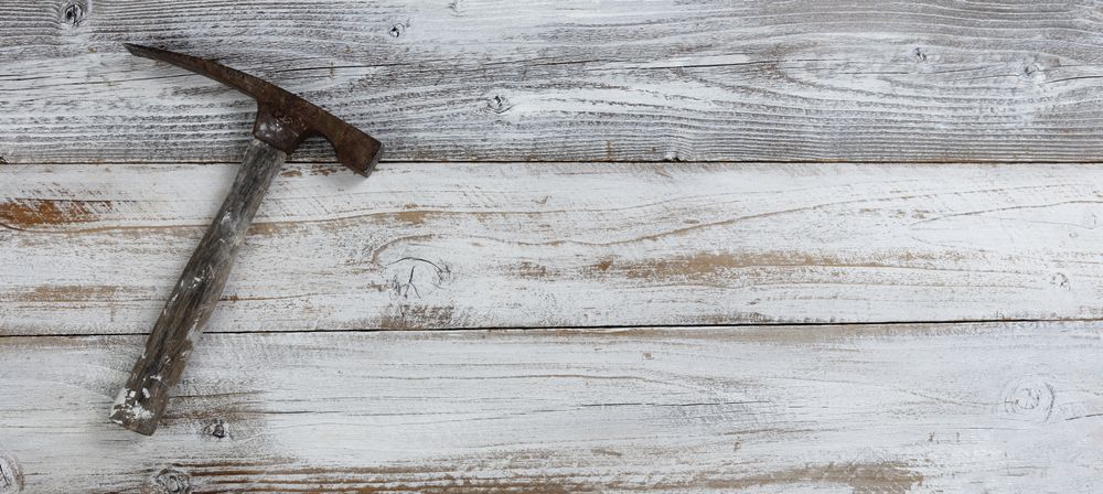 Vintage construction hammer on rustic wooden boards