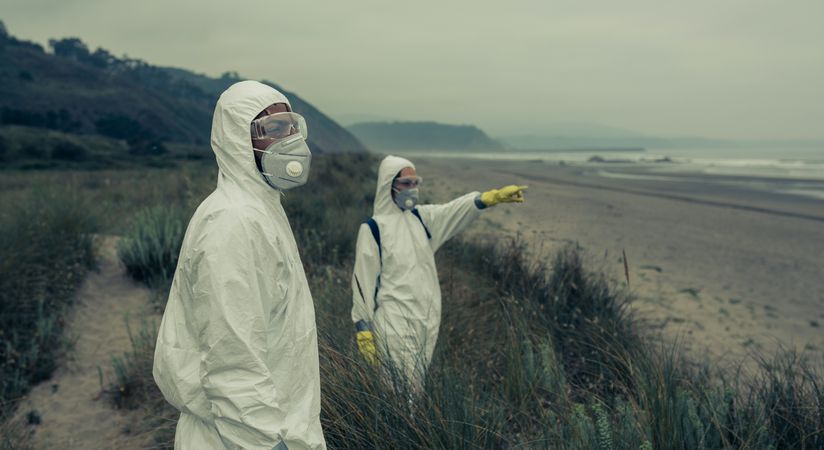People in bacteriological protective suits watching the sea