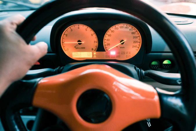 Close up of anonymous hand on steering wheel in sports car