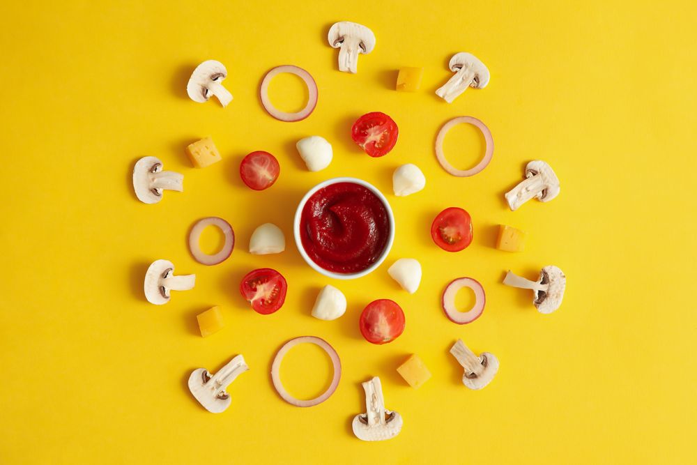 Ingredients for cooking pizza on yellow background