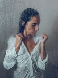 Sensitive woman in glass shower cabin
