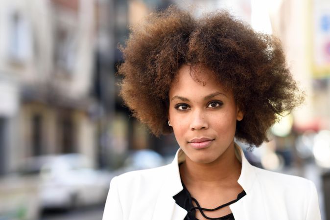 Close up of female in blazer standing on street