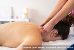 Masseuse massaging neck of woman in spa salon 5zrj6j