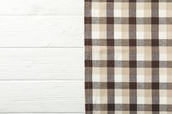 Checkered tablecloth on wooden background, space for text