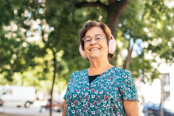 Mature woman walking down the street listening to music