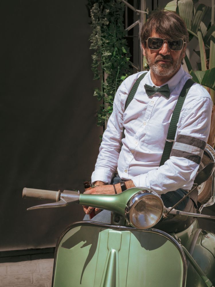 Trendy man sitting on vintage scooter