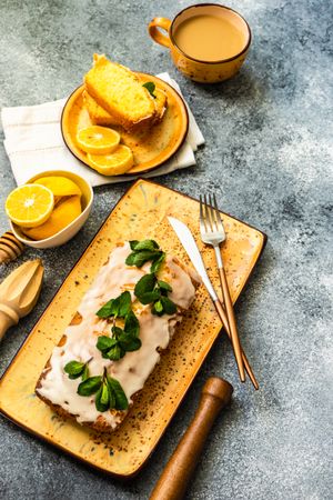 Tasty lemon cake with fresh mint served on orange plates with tea