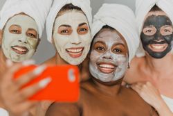 Multiethnic women with face masks taking selfie