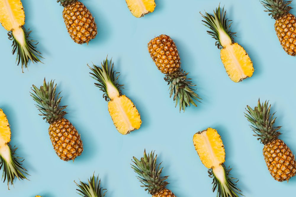 Pineapple in rows on pastel blue background