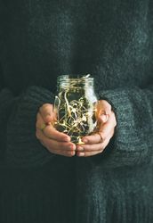 Woman holding glass jay with fairy lights inside