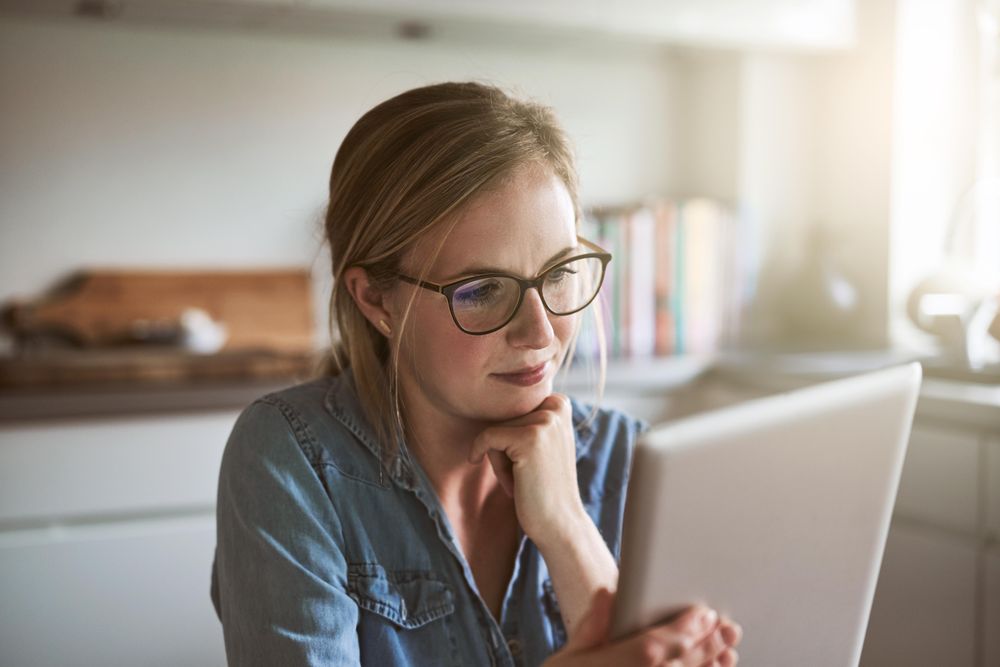 Woman in glasses holding tablet