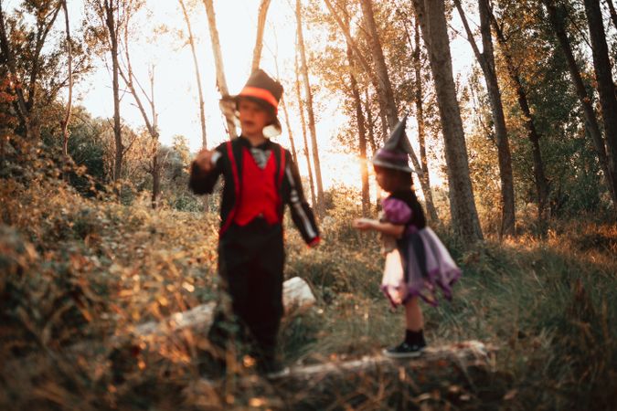 Two children in halloween costumes in the forest