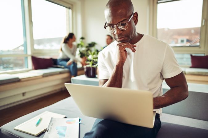 Pensive business man working on his laptop in a bright office