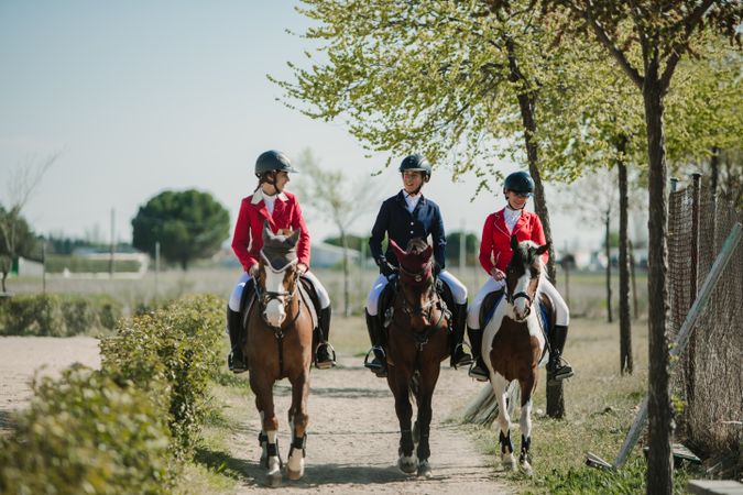 Young horse riders on pathway in nature
